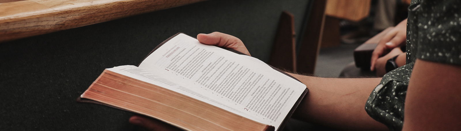 Man holding bible in pew